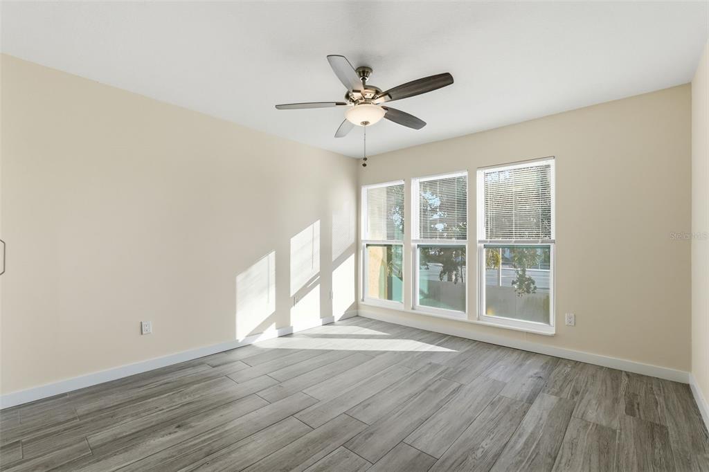 3405 Clark Road, Unit 205 Sarasota, FL 34231 - Photo 17 of 38 an empty room with wooden floor fan and windows