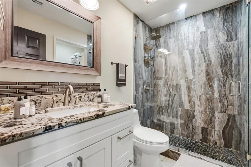 3405 Clark Road, Unit 205 Sarasota, FL 34231 - Photo 20 of 38 a bathroom with a granite countertop sink a toilet and a mirror