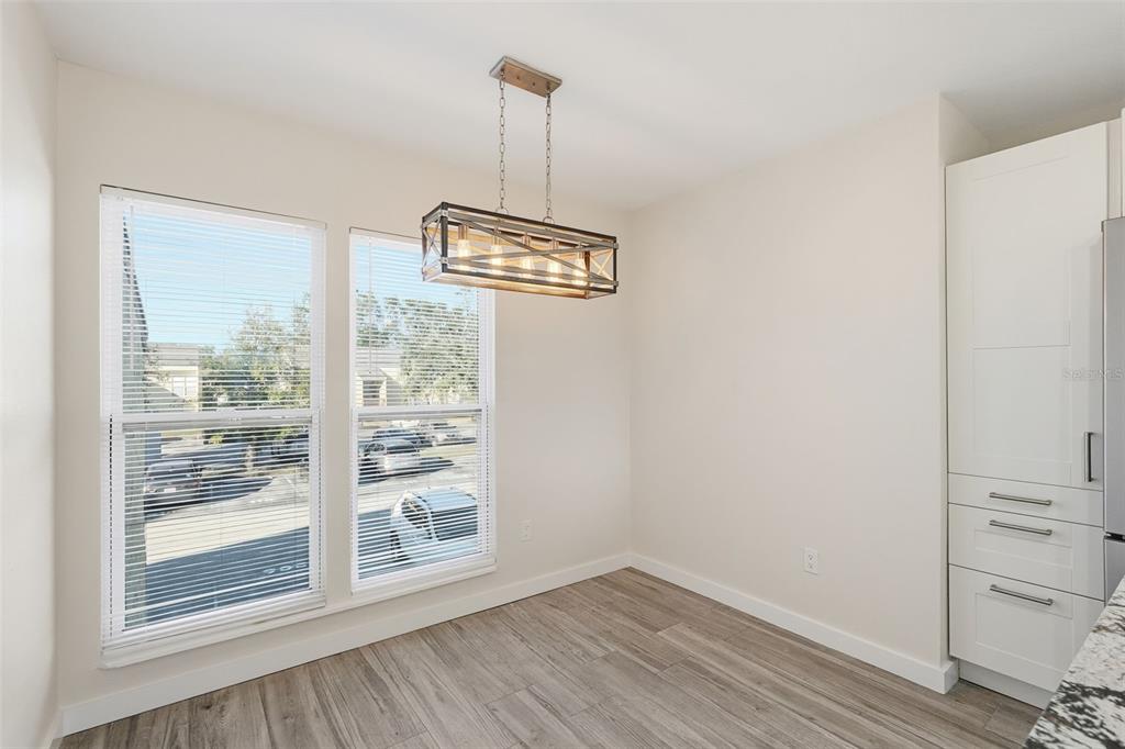 3405 Clark Road, Unit 205 Sarasota, FL 34231 - Photo 3 of 38 a view of an empty room with wooden floor and a window