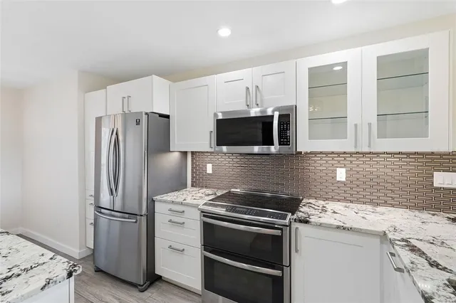 a kitchen with stainless steel appliances a refrigerator stove and microwave