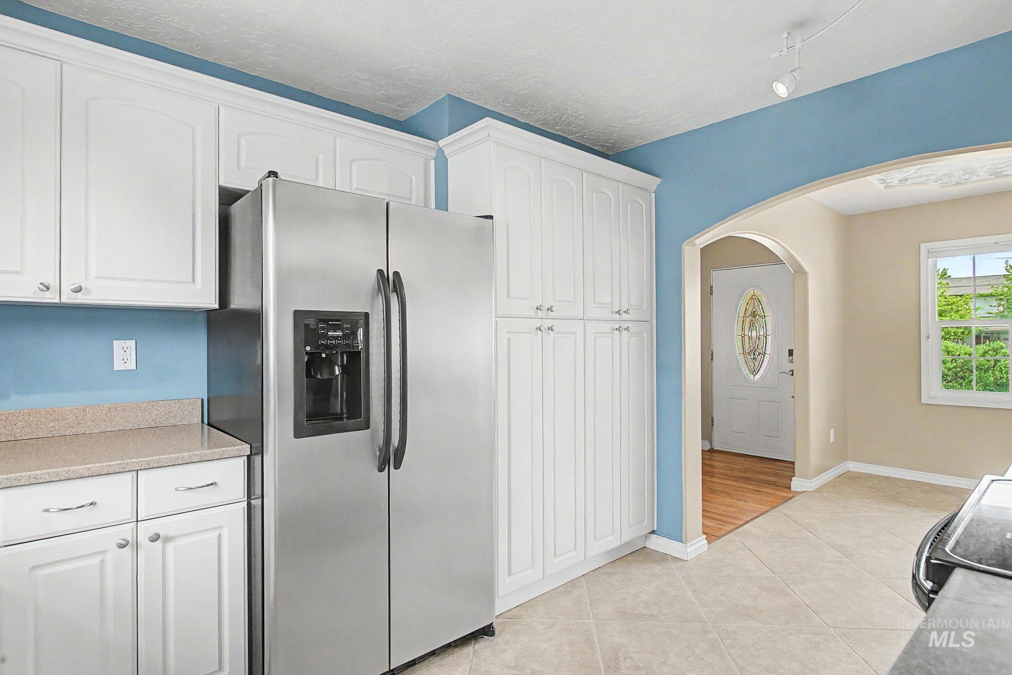 3314 6th Street Lewiston, ID 83501 - Photo 13 of 50 Kitchen featuring white cabinetry, stainless steel side-by-side refrigerator, speckled countertop, and tiled flooring