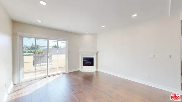 an empty room with wooden floor and fireplace
