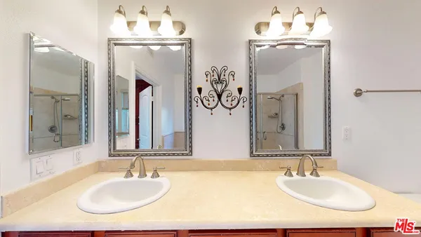 a bathroom with double vanity sinks and a mirror