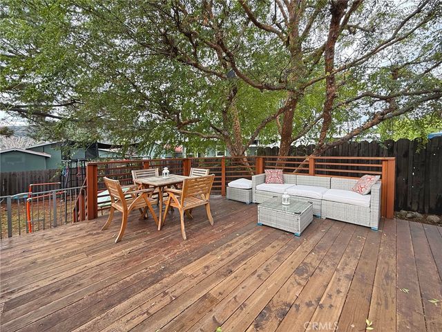 a view of a patio with couches table and chairs under an umbrella with wooden floor