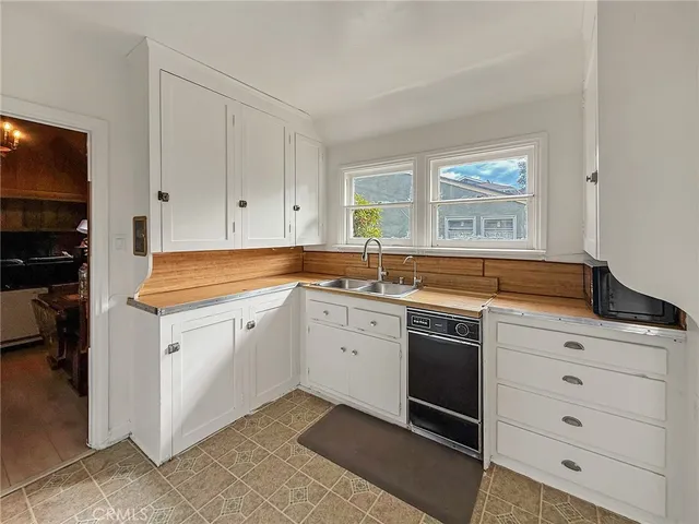 a kitchen with granite countertop white cabinets and white appliances