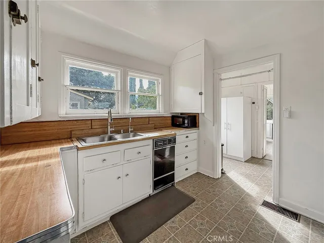 a kitchen with white cabinets and a sink