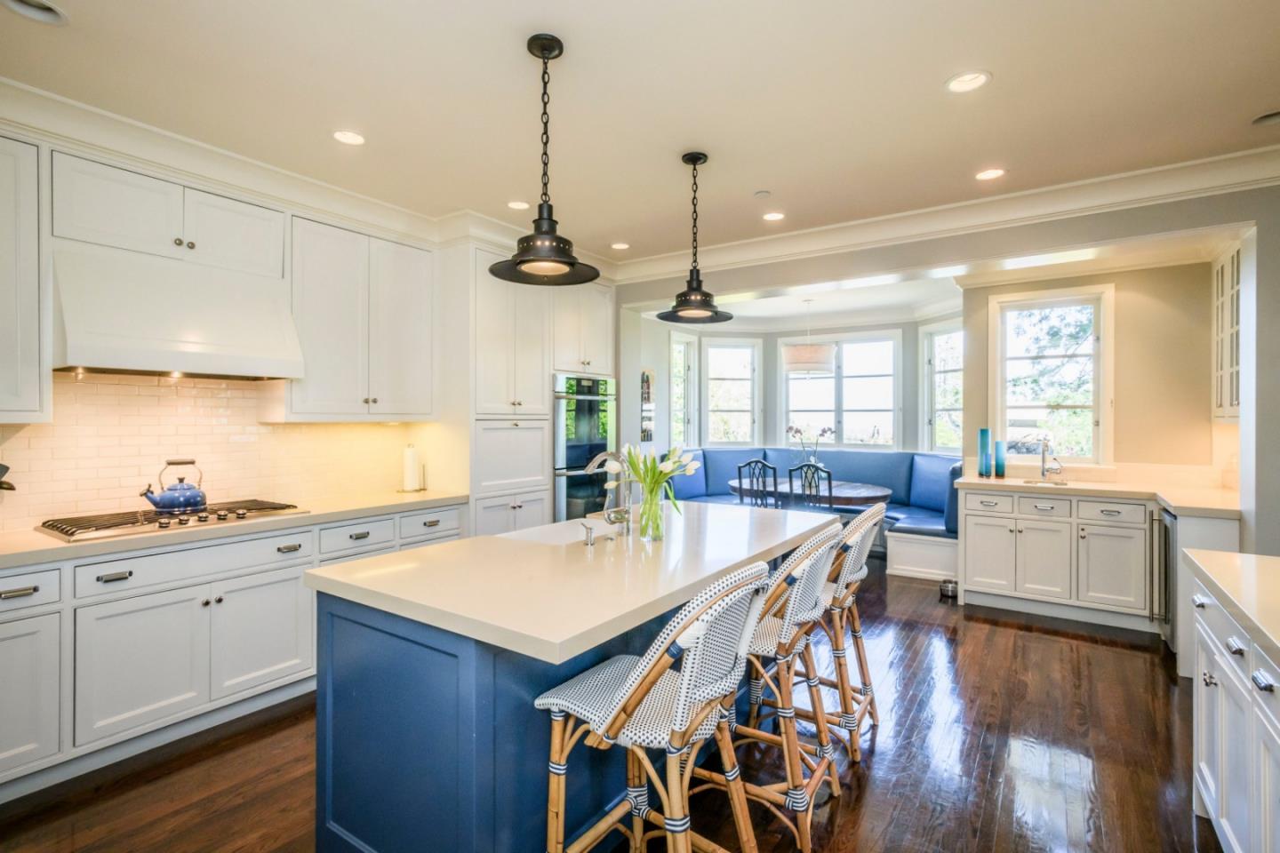 426 El Arroyo Road Hillsborough, CA 94010 - Photo 12 of 50 a kitchen with stainless steel appliances kitchen island granite countertop a stove a sink and white cabinets with wooden floor