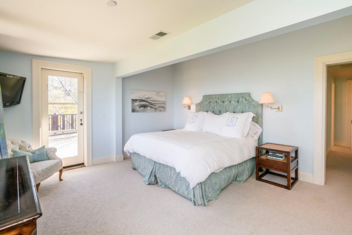 426 El Arroyo Road Hillsborough, CA 94010 - Photo 19 of 50 a spacious bedroom with a bed and a couch