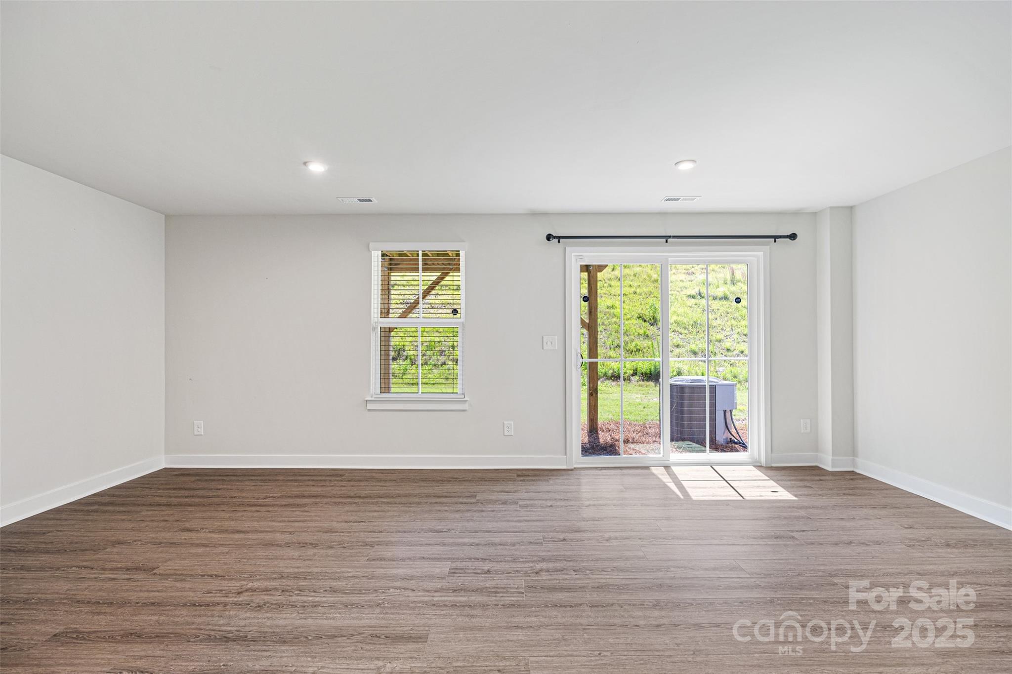 2040 Dornoch Road Tega Cay, SC 29708 - Photo 4 of 30 an empty room with wooden floor and windows