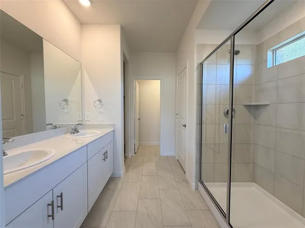 a bathroom with a bathtub shower sink vanity mirror and toilet