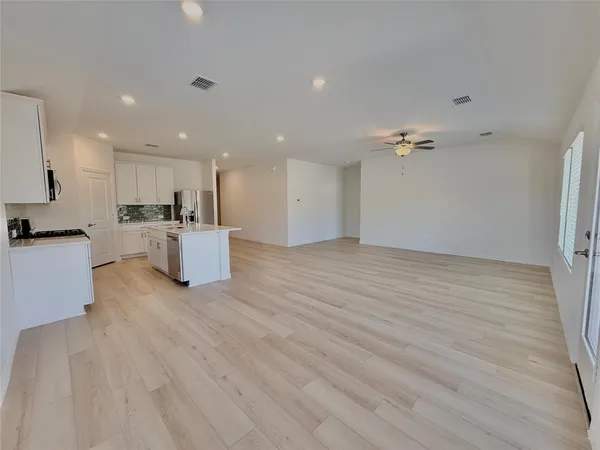 an empty room with a window and a fan