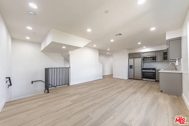 a view of a kitchen with a sink and a refrigerator