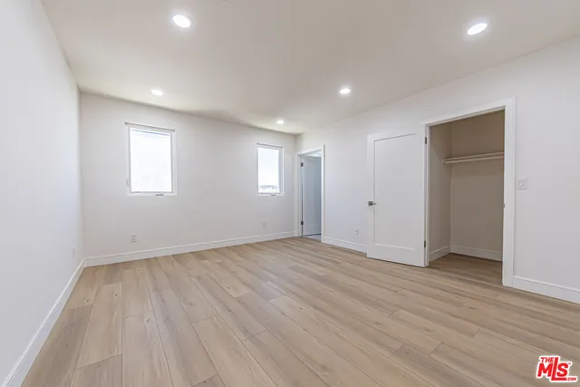 an empty room with wooden floor and window