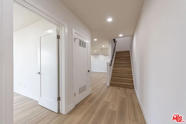 a view of a hallway with wooden floor and entryway