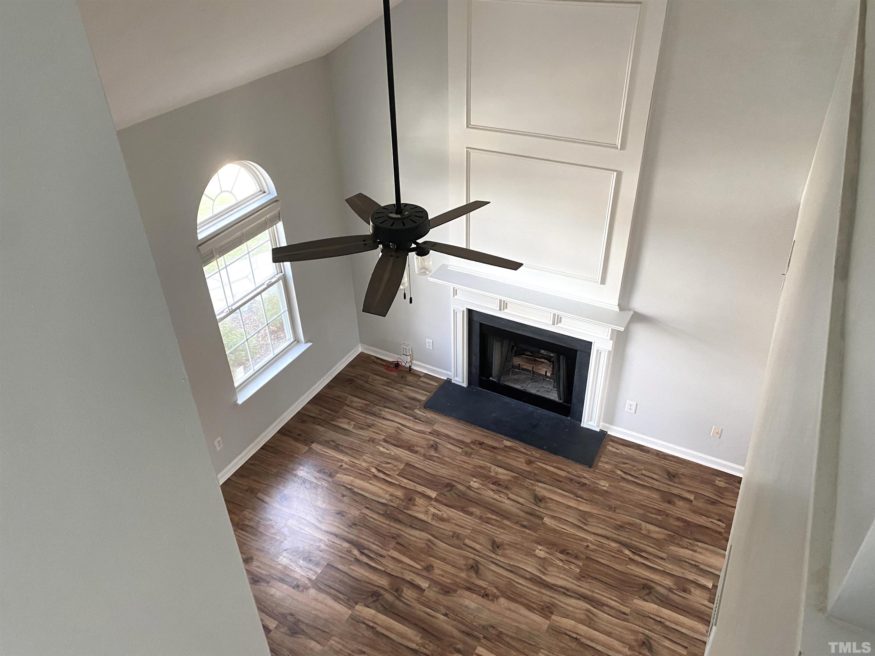 5104 Gable Ridge Drive Durham, NC 27713 - Photo 8 of 16 a view of an empty room with wooden floor fireplace and a window