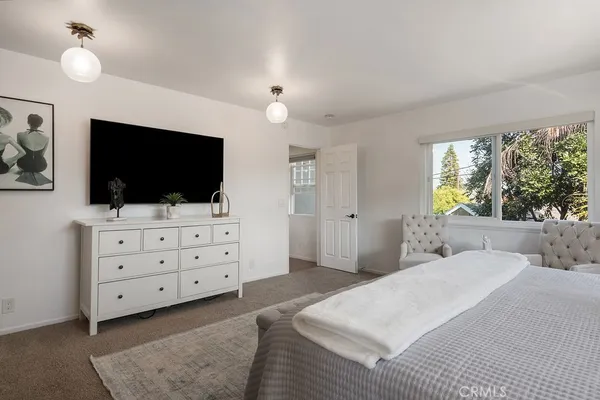 a bedroom with a large bed and a chandelier