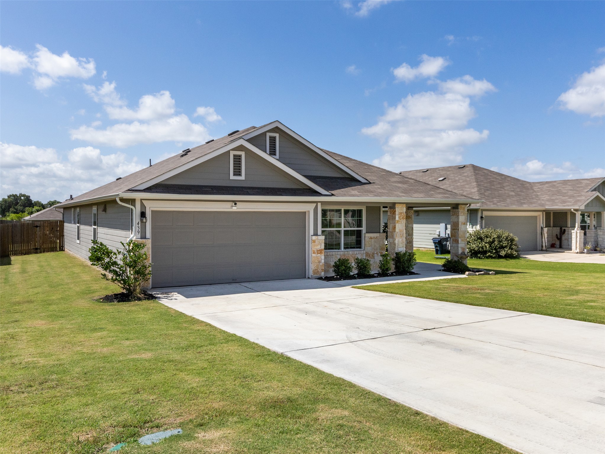 439 Hunter Loop Bertram, TX 78605 - Photo 2 of 23 A welcoming front exterior showcasing a meticulously maintained lawn and a practical driveway.
