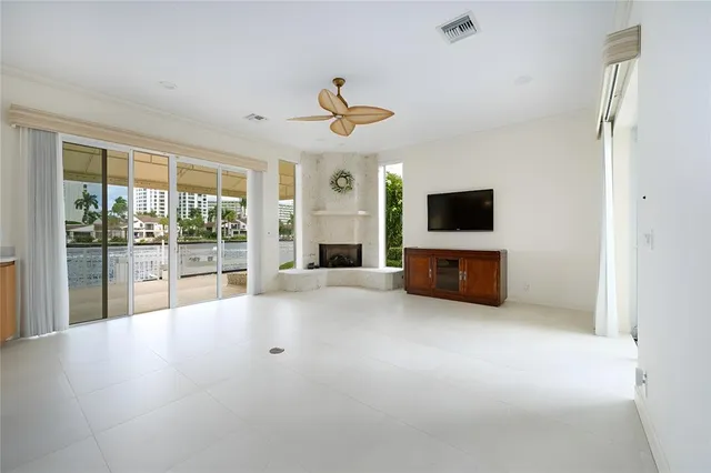 a living room with furniture a flat screen tv and a floor to ceiling window
