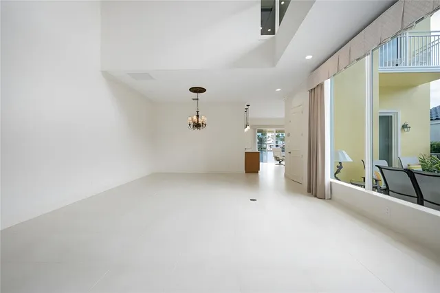 a picture of a room with a chandelier fan and wooden floor