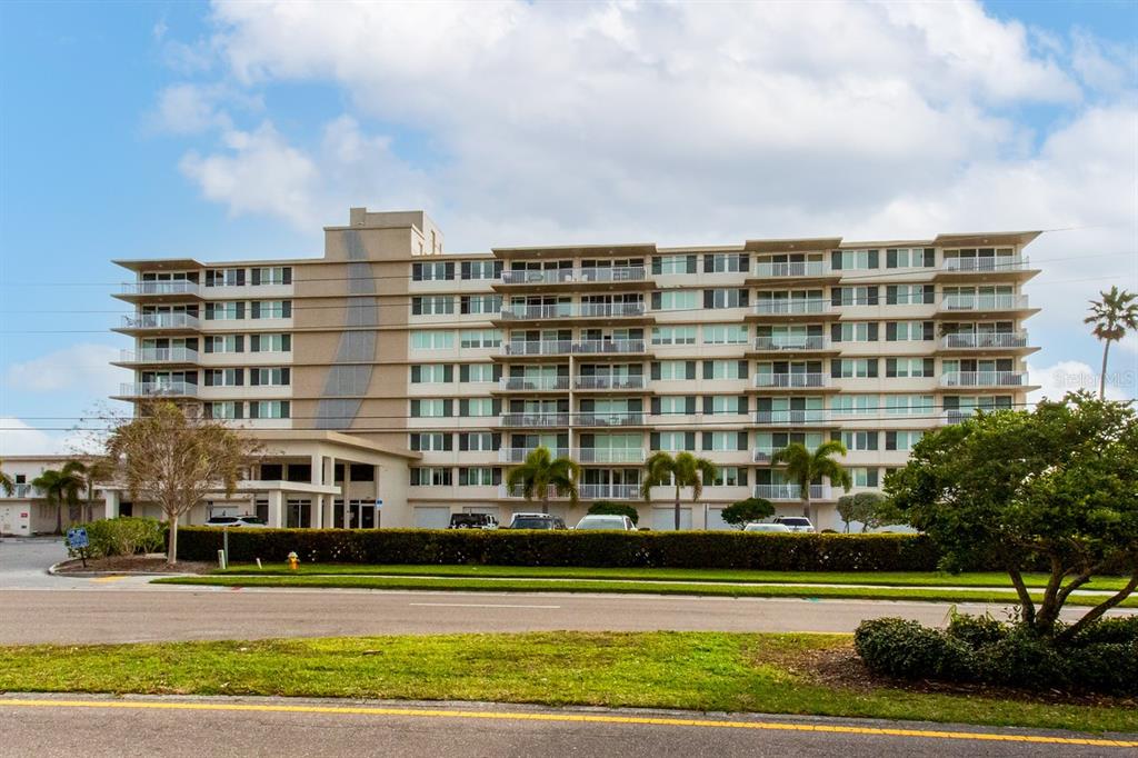 223 Island Way, Unit 2B Clearwater, FL 33767 - Photo 1 of 1 a front view of a building with glass windows and trees