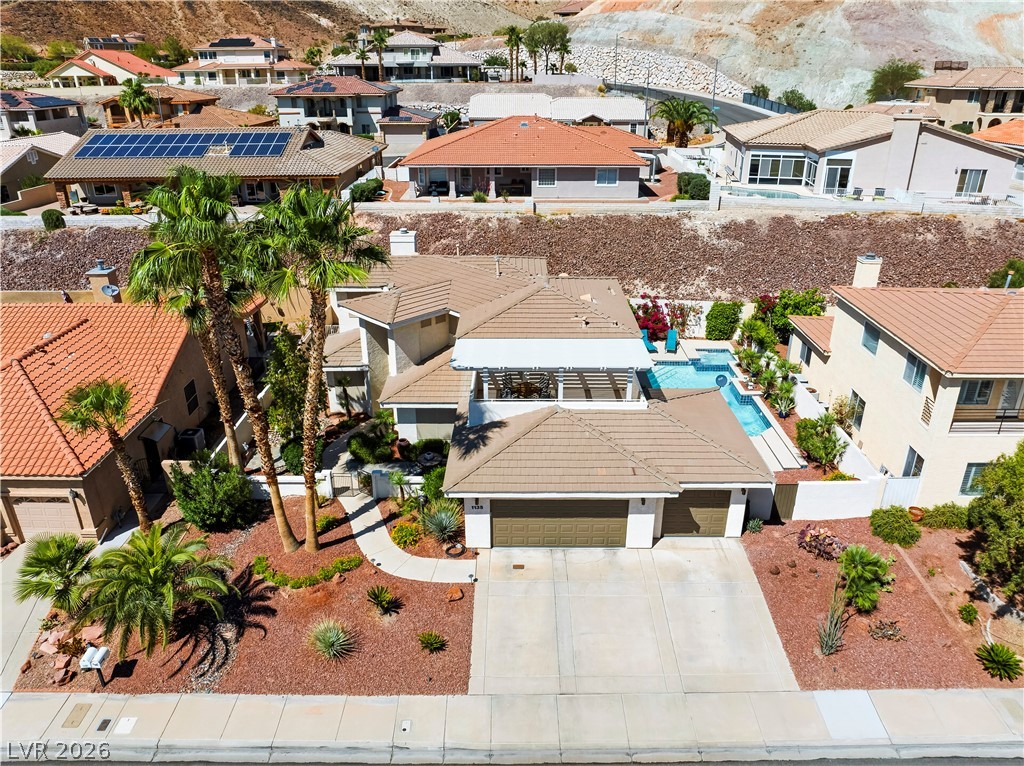 1135 Calico Ridge Drive Henderson, NV 89011 - Photo 56 of 86 An aerial perspective reveals a desert-landscaped front yard and a refreshing backyard pool, all nestled in a hillside community.