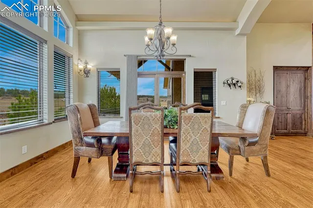 a kitchen with stainless steel appliances kitchen island granite countertop a table chairs and a refrigerator