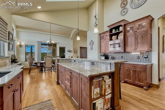 a dining hall with stainless steel appliances granite countertop a stove and cabinets