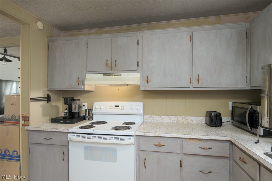 10190 Penniman Road Orwell, OH 44076 - Photo 20 of 24 Kitchen featuring painted cabinetry, a white electric range, and laminate countertops