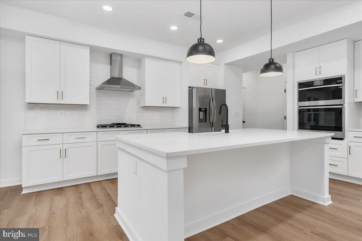 6508 Shady Side Road Shady Side, MD 20764 - Photo 3 of 35 a kitchen with kitchen island a sink stainless steel appliances and cabinets