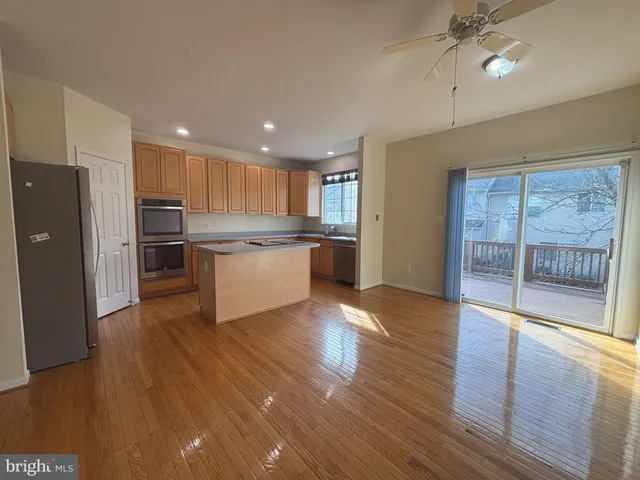 a kitchen with stainless steel appliances granite countertop a refrigerator and a stove top oven