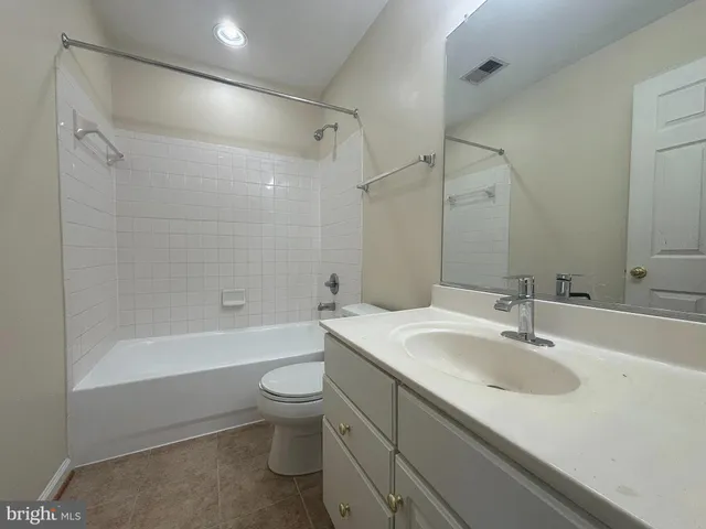 a bathroom with a sink a toilet and a large mirror