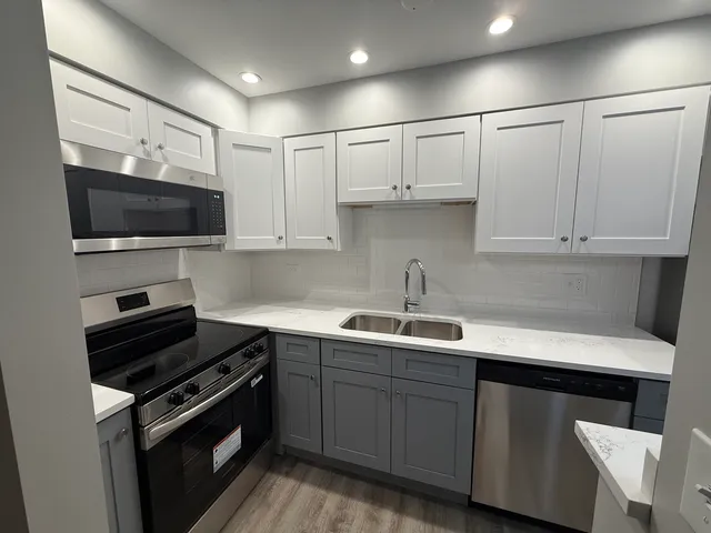 a kitchen with a sink and white cabinets