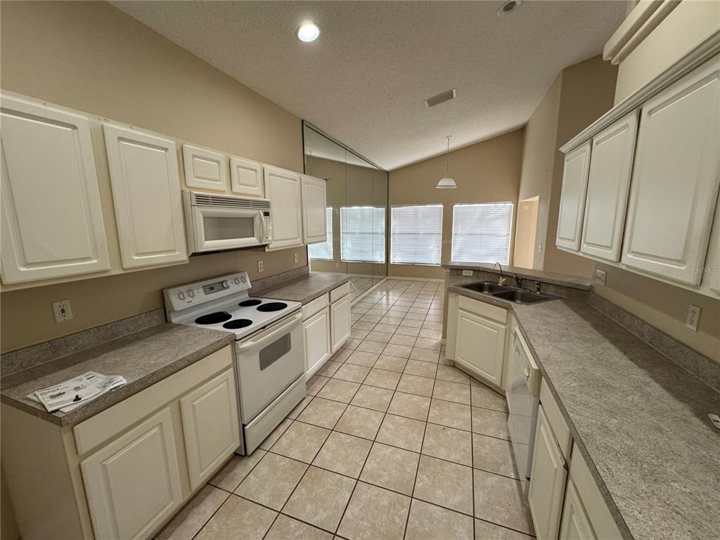 4190 Bear Gully Road Winter Park, FL 32792 - Photo 8 of 30 a kitchen with stainless steel appliances granite countertop a stove a sink and a microwave