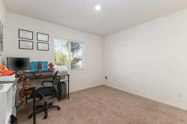 a view of a workspace with furniture and a window