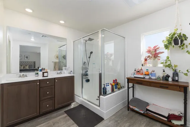 a bathroom with a double vanity sink mirror and bathtub