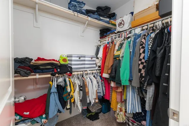 a view of walk in closet with clothes