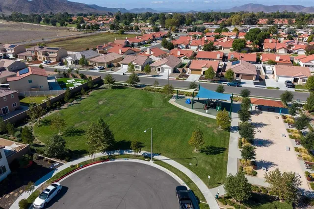 an aerial view of a city with lots of residential buildings ocean and mountain view in back