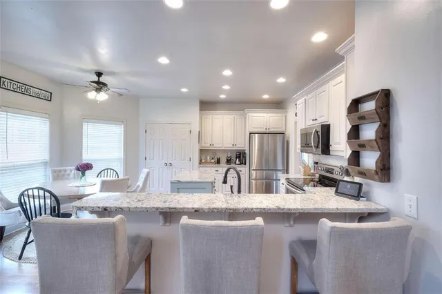 a kitchen with center island cabinets and stainless steel appliances