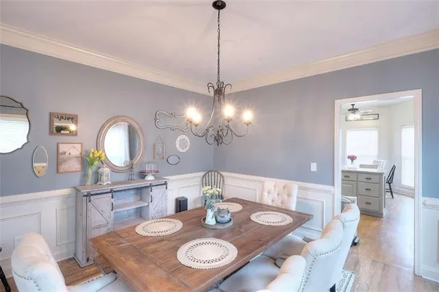 a view of a dining room with furniture a chandelier and wooden floor
