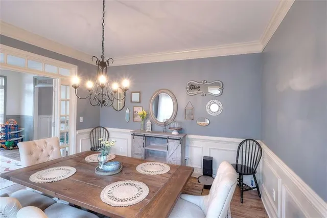 a view of a dining room with furniture a chandelier and wooden floor