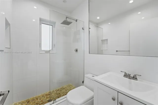 a bathroom with a sink toilet vanity and shower