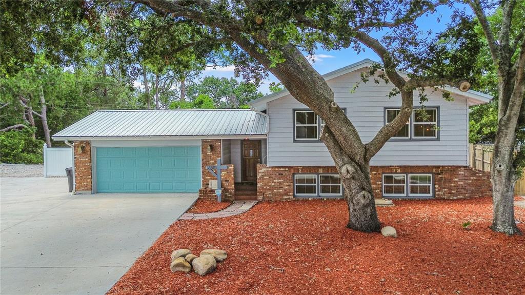 a view of a house with a patio and a yard