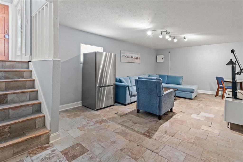 6515 Dimarco Road Tampa, FL 33634 - Photo 24 of 67 a living room with furniture and a chandelier