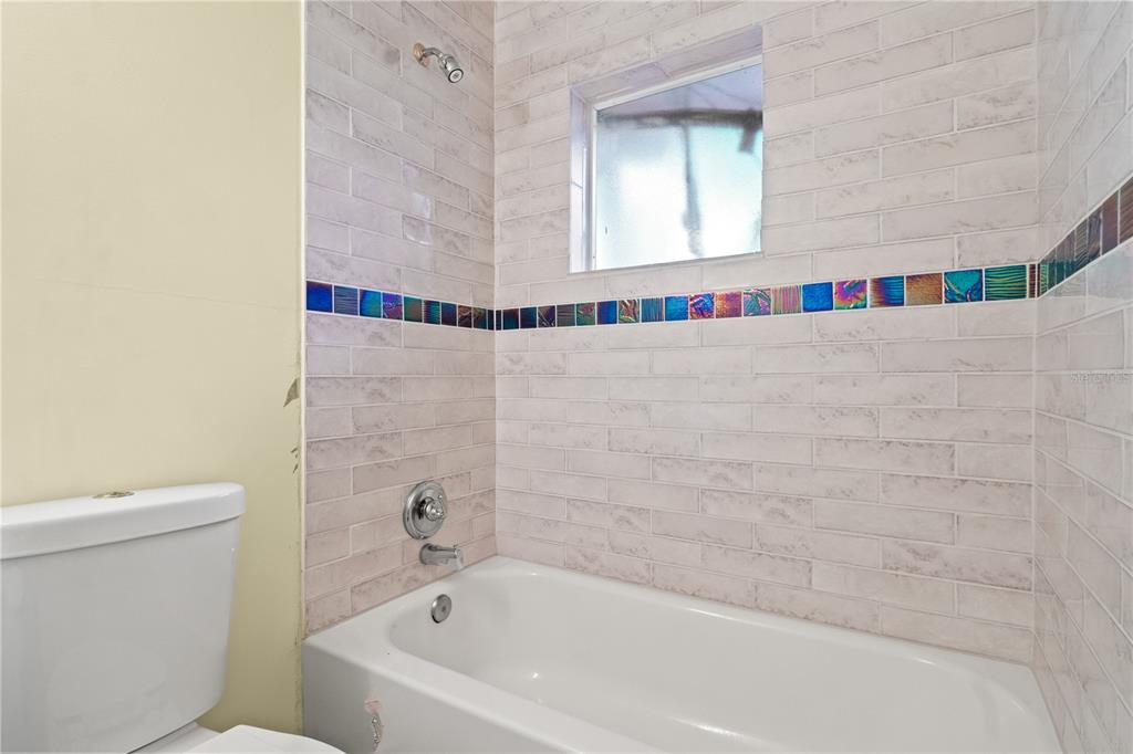 6515 Dimarco Road Tampa, FL 33634 - Photo 31 of 67 a bathroom with a bathtub and a toilet