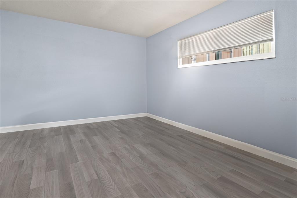 6515 Dimarco Road Tampa, FL 33634 - Photo 32 of 67 a view of an empty room with wooden floor and a window