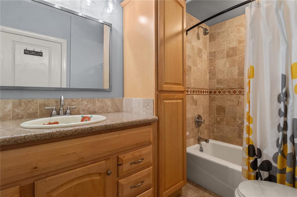 6515 Dimarco Road Tampa, FL 33634 - Photo 50 of 67 a bathroom with a granite countertop sink mirror toilet and bathtub