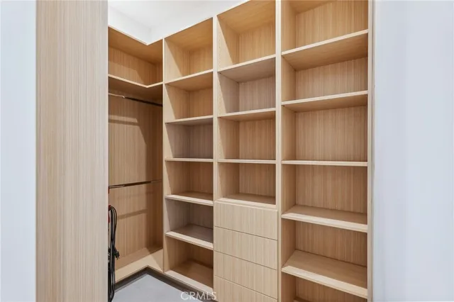 a view of walk in closet with empty racks
