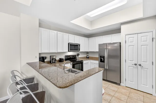 a kitchen with granite countertop white cabinets and white appliances