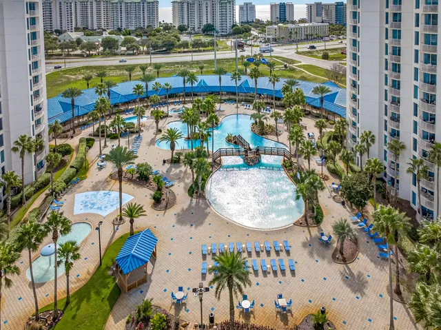 view of a swimming pool with outdoor seating and plants