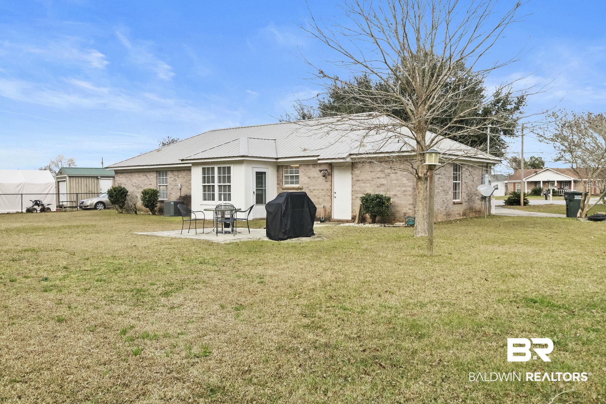 14031 Brook Hollow Road Summerdale, AL 36580 - Photo 47 of 56 Rear view of property with a lawn, cooling unit, and a patio